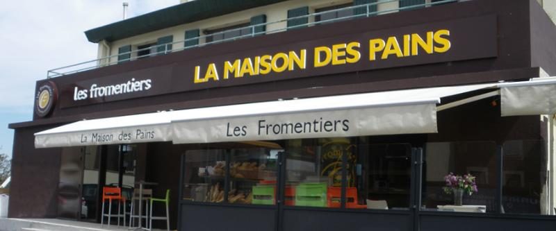 Enseigne lumineuse La Maison des Pains posée sur la devanture d'une boulangerie