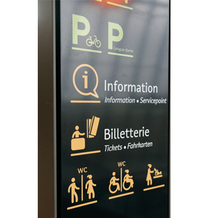 Totem de signalétique intérieure directionnelle installé dans un hall d'accueil