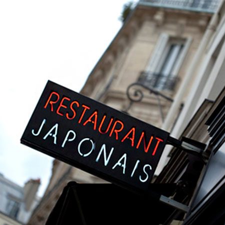 Enseigne noire Restaurant Japonais en applique sur un immeuble ancien