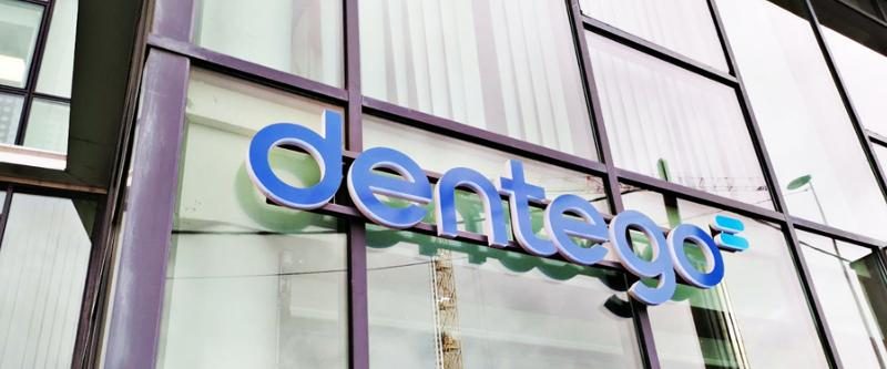 Lettres lumineuses bleues Dentego posées sur la façade vitrée d'un centre dentaire