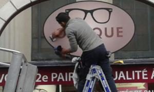 Pose d'adhésif sur la vitrine d'un opticien — JMJ Com, Villeurbanne et Lyon