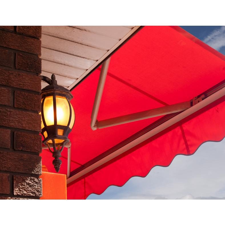 Store banne rouge rentoilé sur une façade en brique après remplacement de la toile