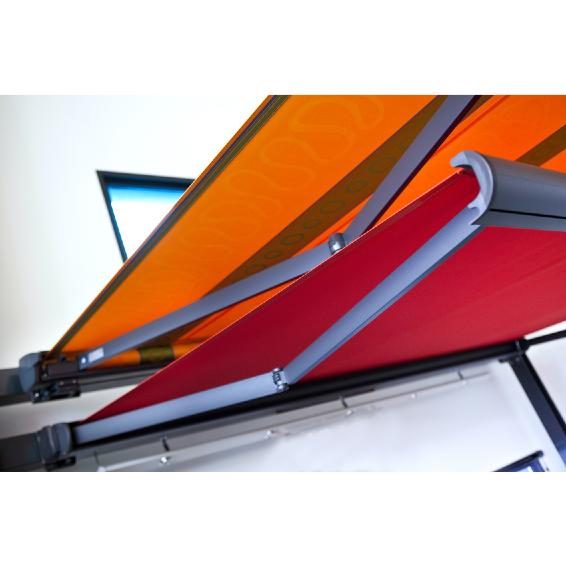 Store banne à toile orange et rouge installé sur la terrasse d'un commerce à Lyon