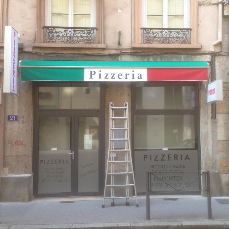 Dépose de l'ancienne enseigne d'une pizzeria avant la pose de la nouvelle